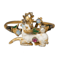 a gold and enamel ring with a deer on it