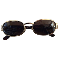 a pair of gold sunglasses on a black background